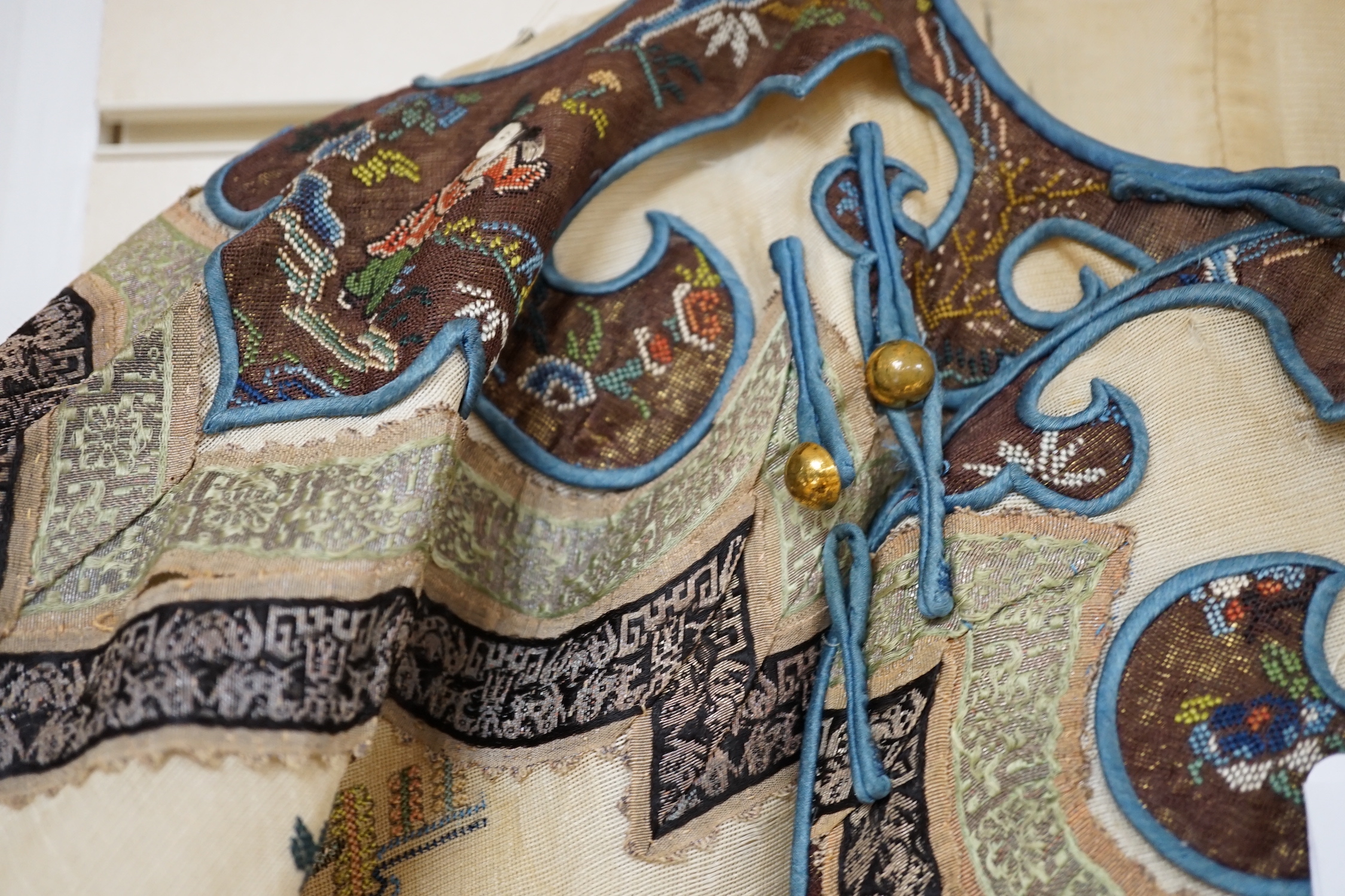 A late 19th/early 20th century Chinese gauze summer robe embroidered with flowers, figures and pagodas, 85cm high